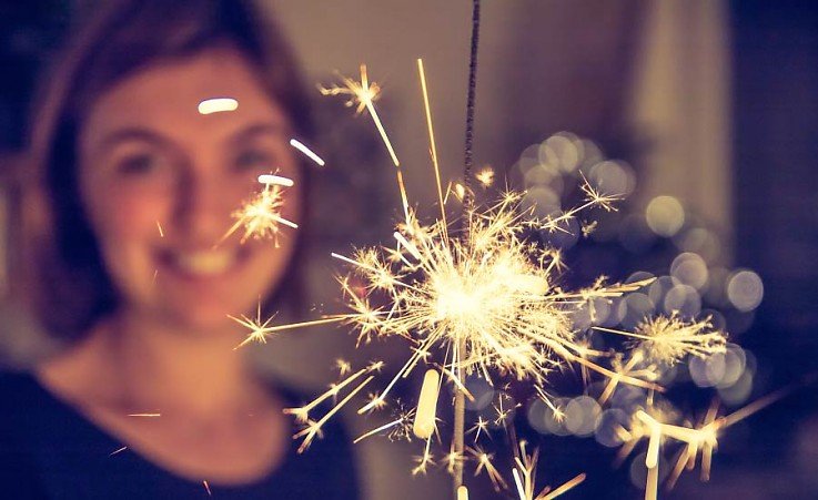 L�chelnde Frau mit Wunderkerze